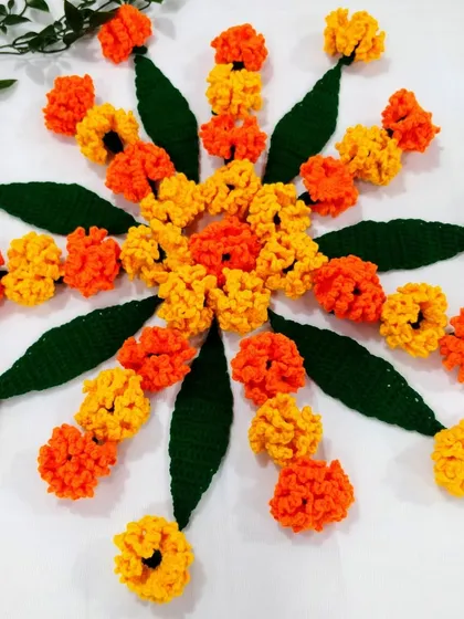 A circular flower rangoli or 'phoolanchi rangoli' made entirely from my crochet marigolds and leaves.