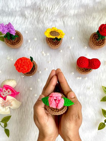 Holding a mini potted tulip, with other potted flowers scattered around. These are so fun to make and collect.