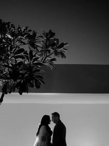 A silhouette of the couple against a simple background. This black and white shot is artistic and minimalist, focusing on their forms and the quiet connection between them.