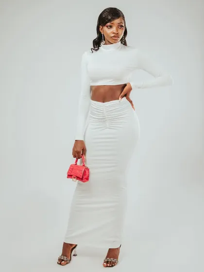 A full-length shot that shows the model's height and the long lines of the skirt.
