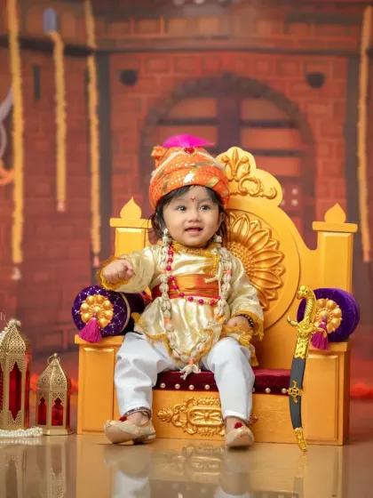 Your little one can be a king for a day with my Bal Shivba theme. This portrait shows a baby boy in full regalia, seated confidently on a golden throne with a decorative lantern and sword prop.