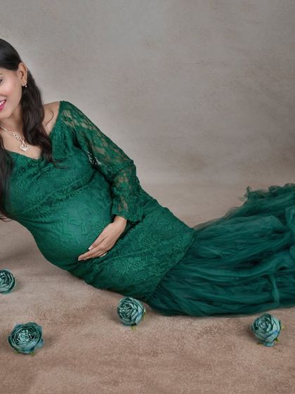 A serene moment on the floor, this pose beautifully showcases the full lace and tulle detail of our popular emerald green gown.