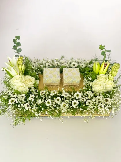 A classic and elegant ring tray for a roka ceremony. The design features a bed of fresh baby's breath and white flowers, creating a soft and romantic look.