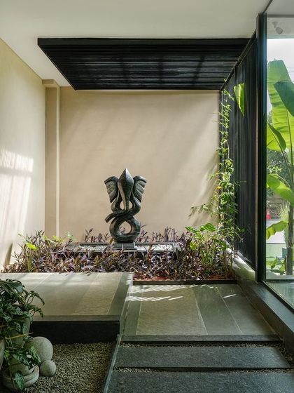 A tranquil corner of a courtyard where a sculptural Ganesha fountain is nestled among plants. This space demonstrates our use of art and water to create focal points that evoke a sense of peace and spirituality.