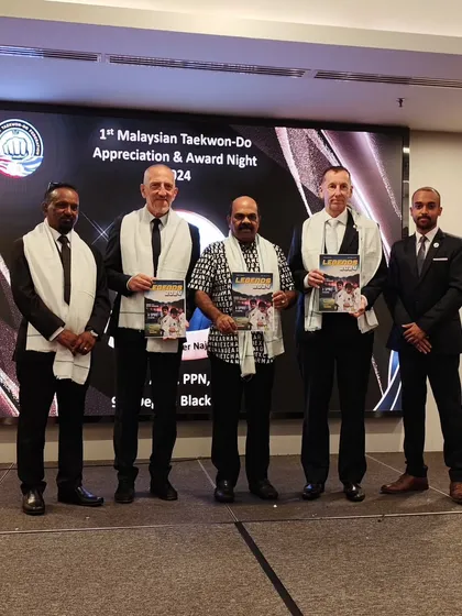 On stage with my seniors and Grand Masters, holding our Legends 2024 magazine.