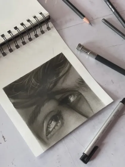 Another angle of the couple's eyes sketch, showing the tools I used.