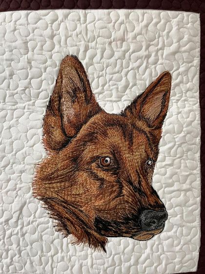 A close-up of the German Shepherd portrait from the dog-themed art quilt, showing the detailed thread painting.