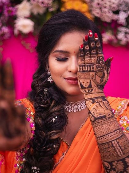 A classic "peek-a-boo" pose with an artistic touch. The focus is sharp on the front hand, creating a sense of depth and drawing attention to the groom's portrait.
