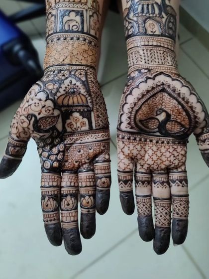 This bridal mehendi features stunning architectural details, including domes and arches, alongside a peacock in a heart shape.
