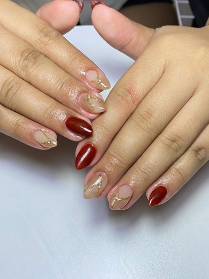 A sophisticated design with a mix of solid deep red and a nude base with abstract gold foil accents.