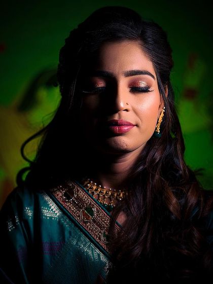 A quiet, contemplative portrait of the bride. The green background complements her attire, and the soft light on her face creates a serene mood, perfect for capturing the moments before a ring ceremony.