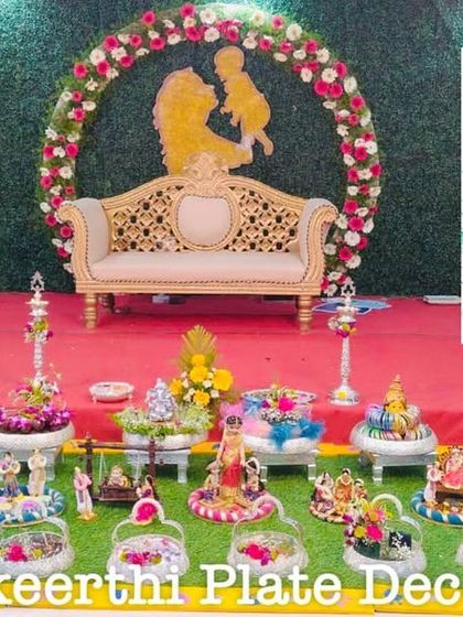 A lovely baby shower setup with a mother and child themed backdrop. My platter arrangements in the front are filled with thematic dolls and colorful gifts.