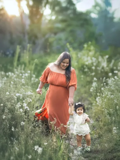A mother and her little one walking hand-in-hand through a field of wildflowers during golden hour. My outdoor sessions are all about capturing these unscripted, magical moments in beautiful natural light.