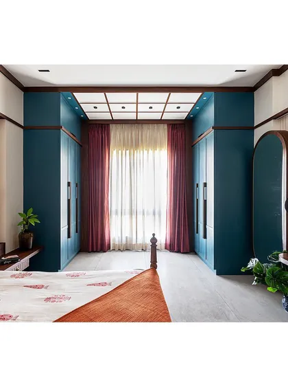 This wide shot shows the full layout of the bedroom, including the 'his and hers' wardrobes that frame the window, creating a beautiful and functional focal point.