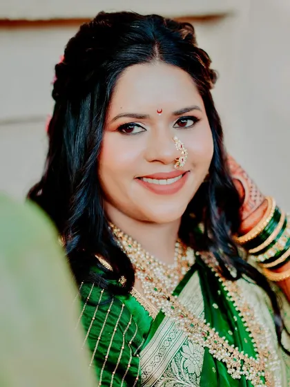 A close-up of this beautiful bride in her emerald green saree. Her makeup is kept soft and natural to let her own radiance shine, complemented by a traditional nath.