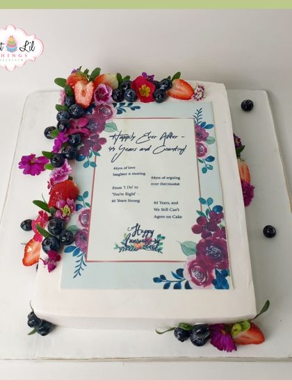 A cake that tells a love story. This unique anniversary cake is designed like a card, complete with a heartfelt message and adorned with fresh berries and flowers.