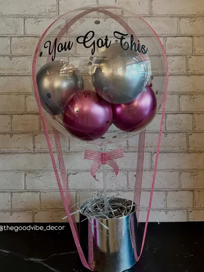 A perfect gift to offer some encouragement. This "You Got This" Bobo Box features a mix of metallic pink and silver balloons in a silver container, offering a modern and uplifting vibe.
