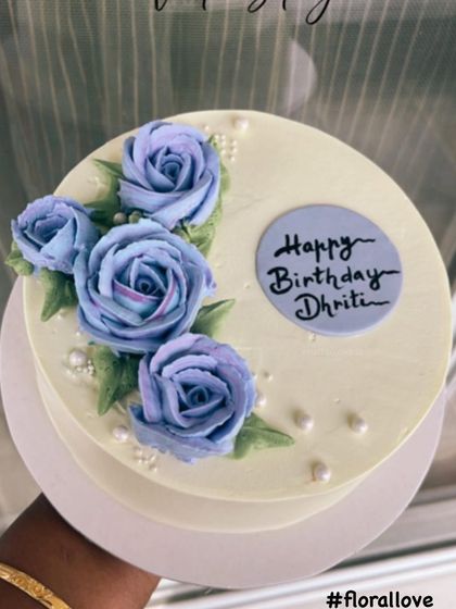 A client photo of our hand-piped blue floral cake. We love seeing our creations as part of your special moments.
