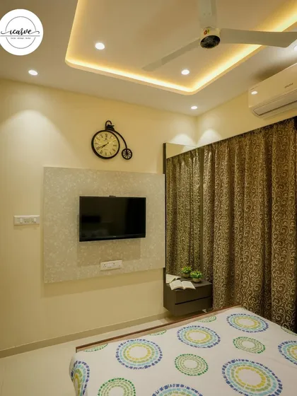This bedroom features a simple TV panel with a textured finish and a unique bicycle-shaped clock.