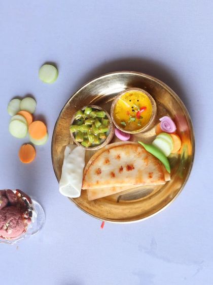 A miniature North Indian thali with a side of ice cream, a perfect combination of savory and sweet.