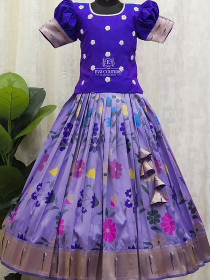 A beautiful floral printed lehenga in a soft lavender shade. The solid purple blouse with puff sleeves and subtle embroidery makes the printed skirt stand out.