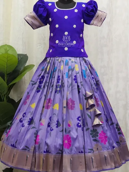 A beautiful floral printed lehenga in a soft lavender shade. The solid purple blouse with puff sleeves and subtle embroidery makes the printed skirt stand out.