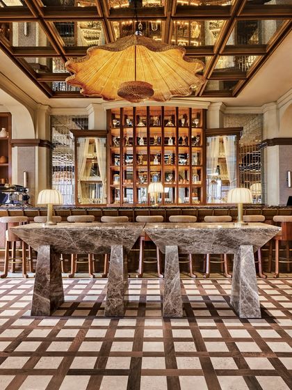 A full view of the bar area at One 8 Commune, showcasing the stunning checkerboard floor and the massive, sculptural marble tables. My surface solutions here are designed to be both beautiful and incredibly durable for a bustling restaurant environment.