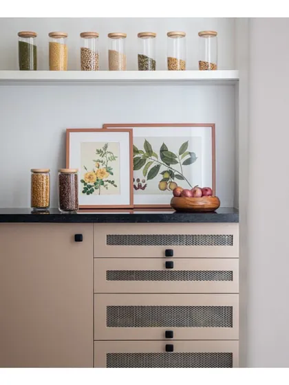Smart and stylish storage in the kitchen pantry area. We used a muted color for the cabinetry with mesh-fronted drawers and framed botanical art to make even the most functional spaces beautiful.