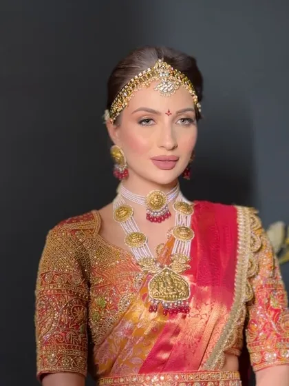 A stunning South Indian bridal look, featuring a traditional braid, temple jewelry, and a matha patti for a complete regal look.