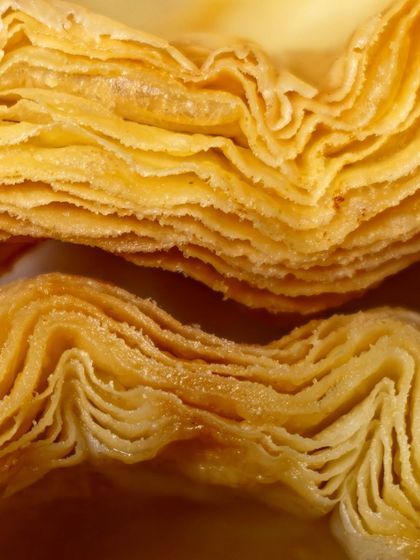 The beautiful, paper-thin layers of our laminated dough, ready to be turned into croissants and puffs.