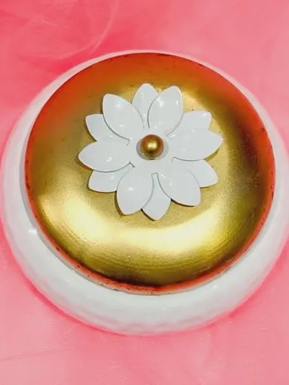 The details make the gift special. This is a close-up of one of my popular packaging options: a beautiful white and gold metal box with a lotus handle, perfect for holding festive items like a blouse piece, bangles, or a kumkum set.