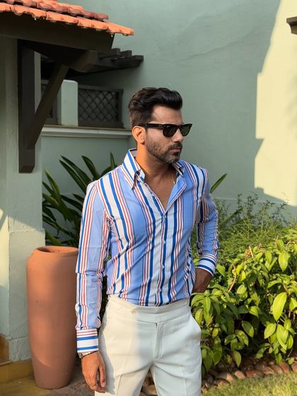 The striped shirt styled in a garden setting, showcasing its crisp lines and vibrant colors that are perfect for daytime events.