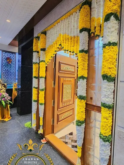 A main door decorated with yellow and white flower garlands for a bright and cheerful welcome.