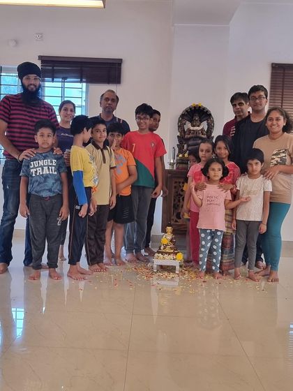 Another view of the children gathered around the Buddha statue. In these simple acts, they learn about peace, respect, and the beauty of shared celebration.