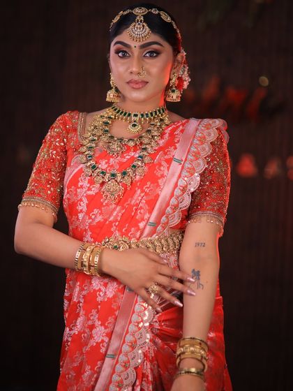 This stunning red floral saree is styled for a high-fashion bridal shoot. The drape is immaculate, designed to look dramatic and beautiful on camera.