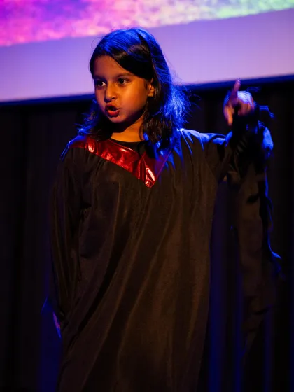 A solo shot of a young actress in character, using a pointed finger to make a dramatic statement. This shows a clear understanding of gesture and intention.