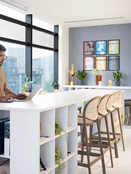 Modern workspaces should be flexible. This collaborative zone features a high-counter with integrated storage and comfortable bar stools, providing an alternative to traditional desks and encouraging dynamic interaction within the office.