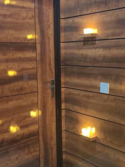 The "after" shot of an entrance transformation in Noida. We used warm wood-look panels and integrated lighting to create a welcoming and modern entryway.