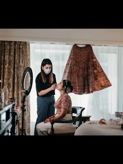 A picture that captures the essence of my work. Here I am, in my element, creating a beautiful bridal look with a classic floral bun.