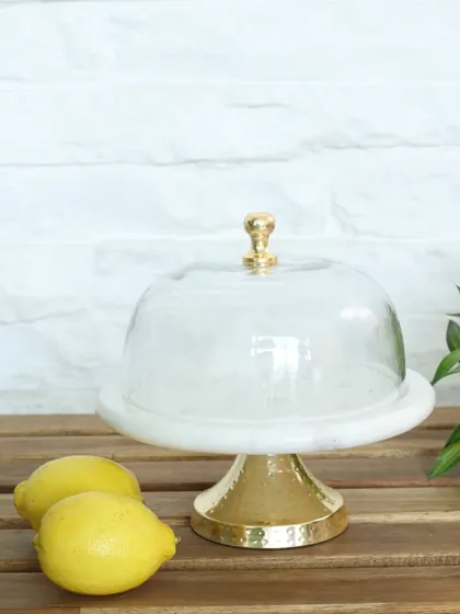 Our classic cake stand featuring a white marble top and a polished gold base, complete with a glass cloche. It’s a timeless piece for showcasing your baking creations in style.