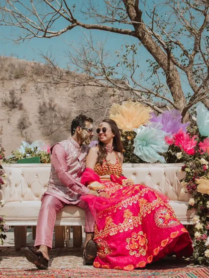 A vibrant Haldi celebration set against a stunning mountain backdrop. The couple, covered in turmeric, shares a happy moment, showcasing the fun and festive atmosphere of the day.