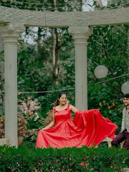 A couple relaxes at a white colonnade set in the garden, an elegant and peaceful setting.