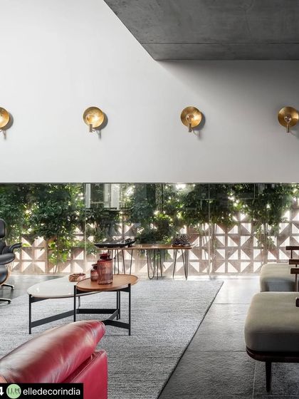 The geometric terracotta screen filters the view to the outside, creating privacy while allowing diffused light to enter the living space. This detail adds a layer of texture and security without sacrificing the home's open and airy feel.