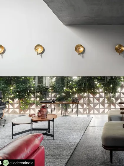 The geometric terracotta screen filters the view to the outside, creating privacy while allowing diffused light to enter the living space. This detail adds a layer of texture and security without sacrificing the home's open and airy feel.
