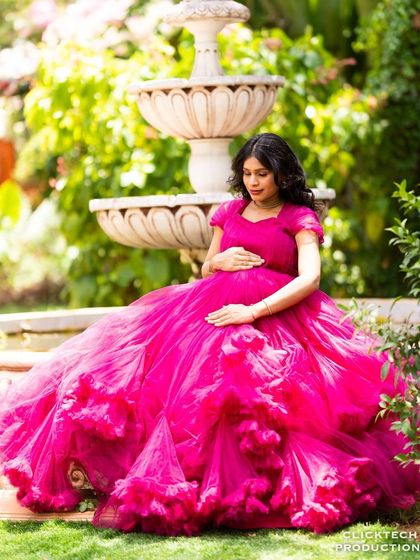 A peaceful maternity portrait by the garden fountain, a classic and elegant setting.