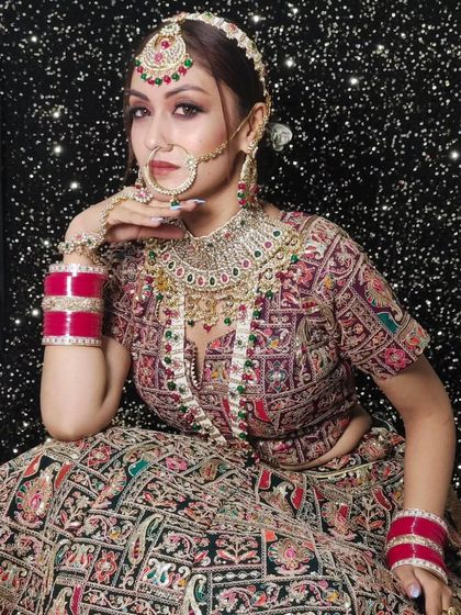 A model in a heavily embroidered lehenga wearing a multi-colored stone and Kundan jewellery set. The sparkling background adds a touch of glamour.