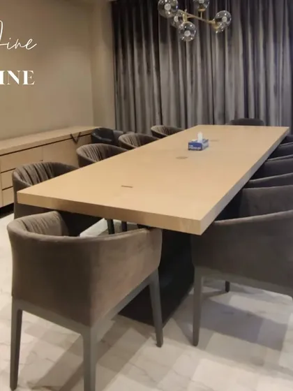 A formal dining setup designed for entertaining. The long table is paired with comfortable upholstered chairs, perfect for long dinners with friends and family.