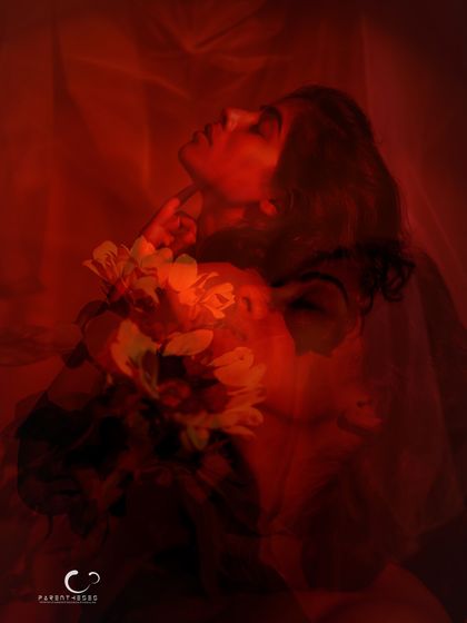 A dreamy and surreal double exposure. The layers of her face and the flowers, all bathed in red, create a complex story of passion, thought, and identity.