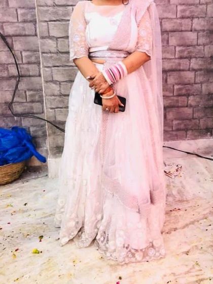 This elegant white embroidered lehenga is a popular choice for engagements and daytime events. The delicate threadwork gives it a soft, romantic feel.