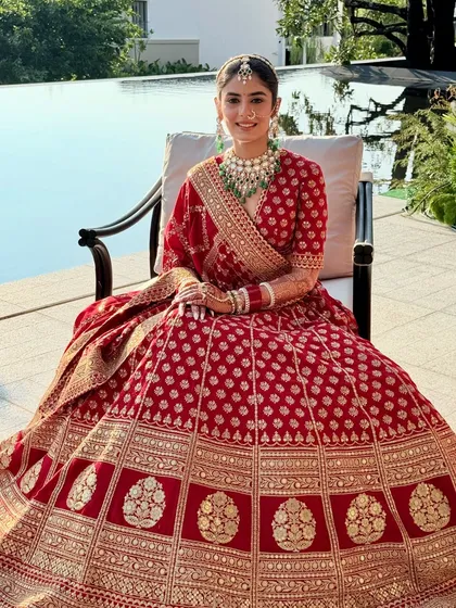 A moment of pure bridal joy. Anmol seated by the pool, her red lehenga and glowing makeup creating a picture-perfect memory.